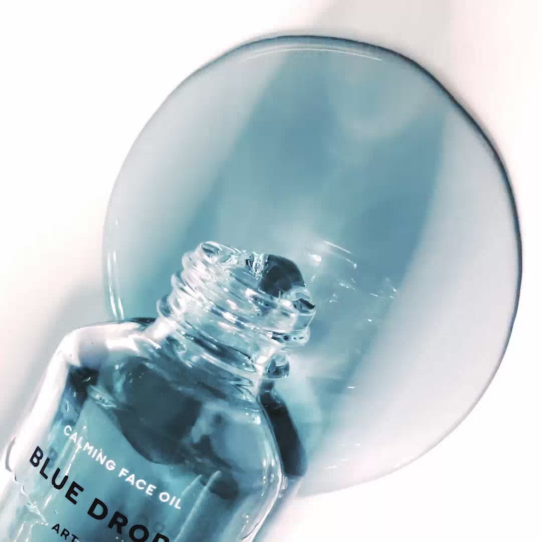 Close-up of RAAW Alchemy Blue Drops being dispensed, showcasing the pure blue oil for soothing redness.