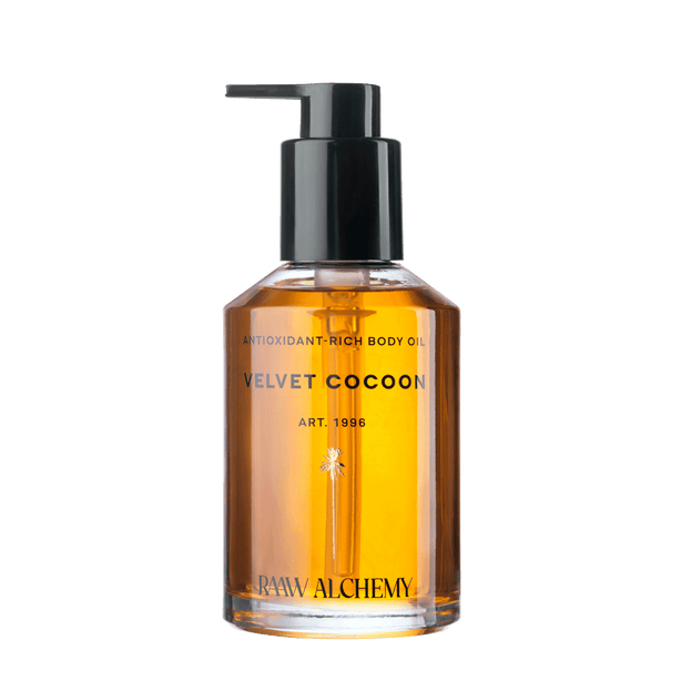 RAAW Alchemy Velvet Cocoon Antioxidant-Rich Body Oil in a luxury glass bottle with pump.