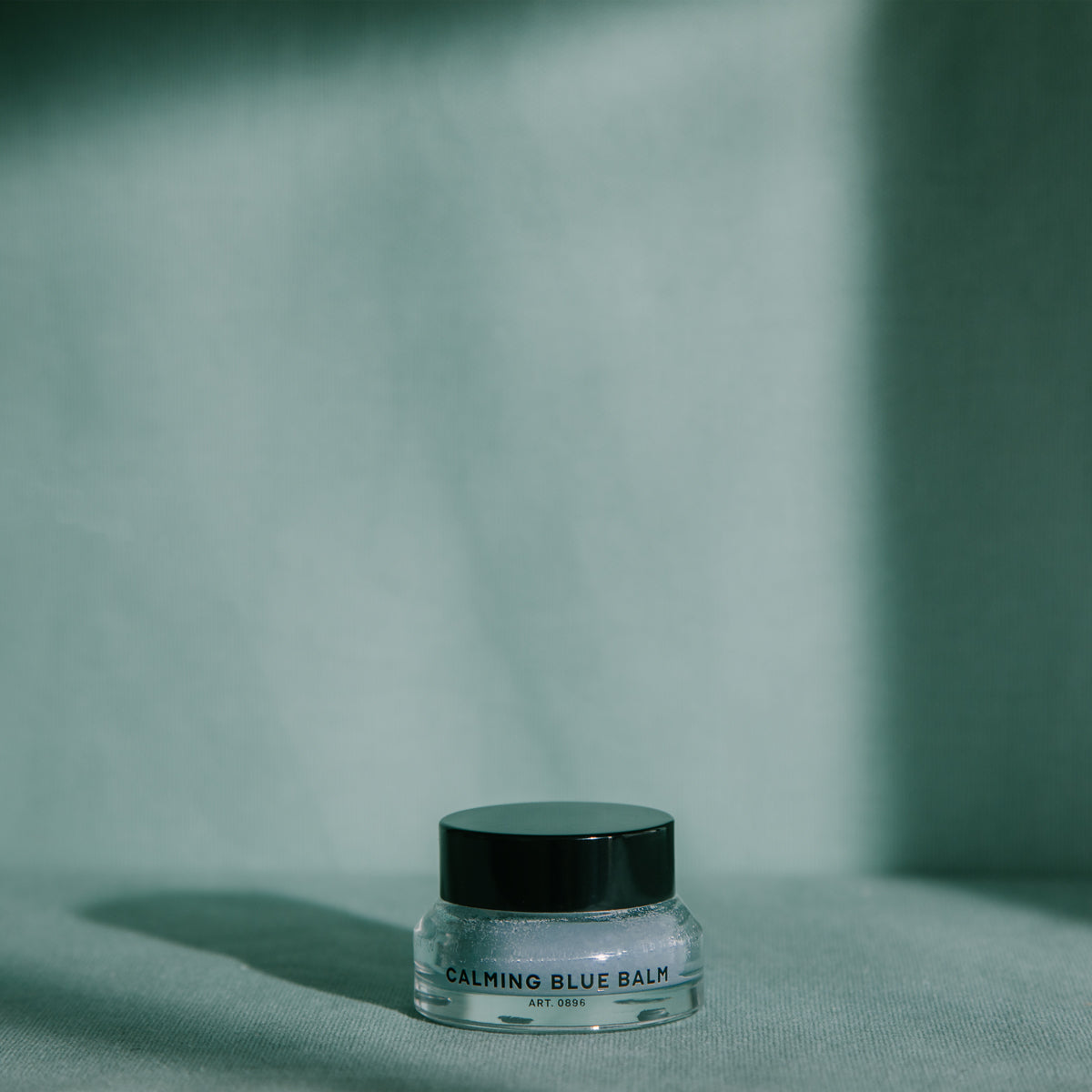 RAAW Alchemy Calming Blue Balm displayed in minimalist aesthetic lighting, perfect for a nighttime skincare ritual.