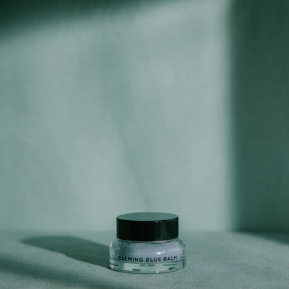 RAAW Alchemy Calming Blue Balm displayed in minimalist aesthetic lighting, perfect for a nighttime skincare ritual.